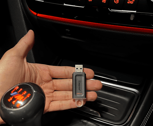 USB flash drive held near car center console USB port