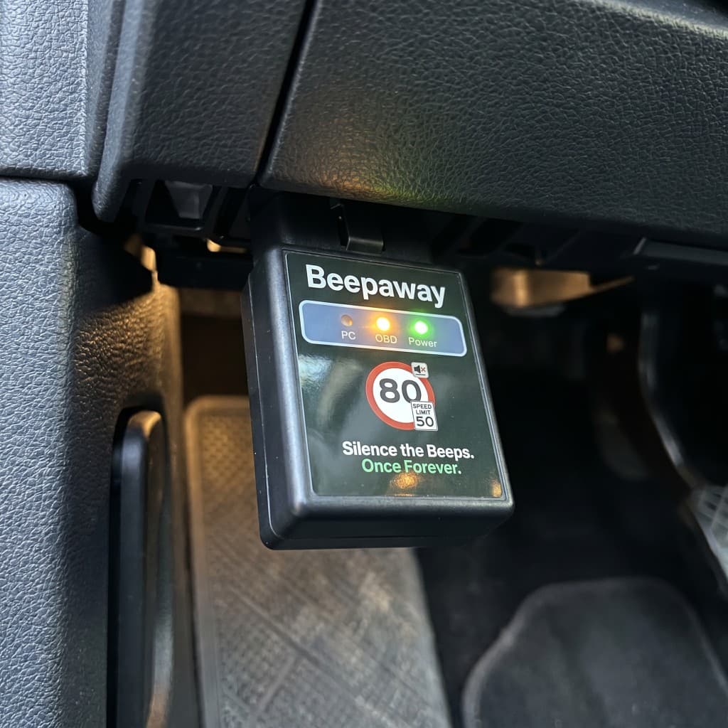 Beepaway dongle installed in vehicle OBD port under the dashboard